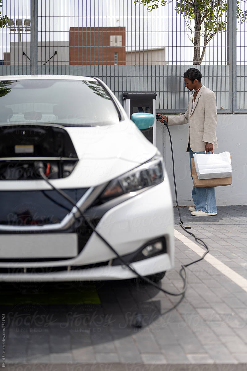 Black man charging an electric car