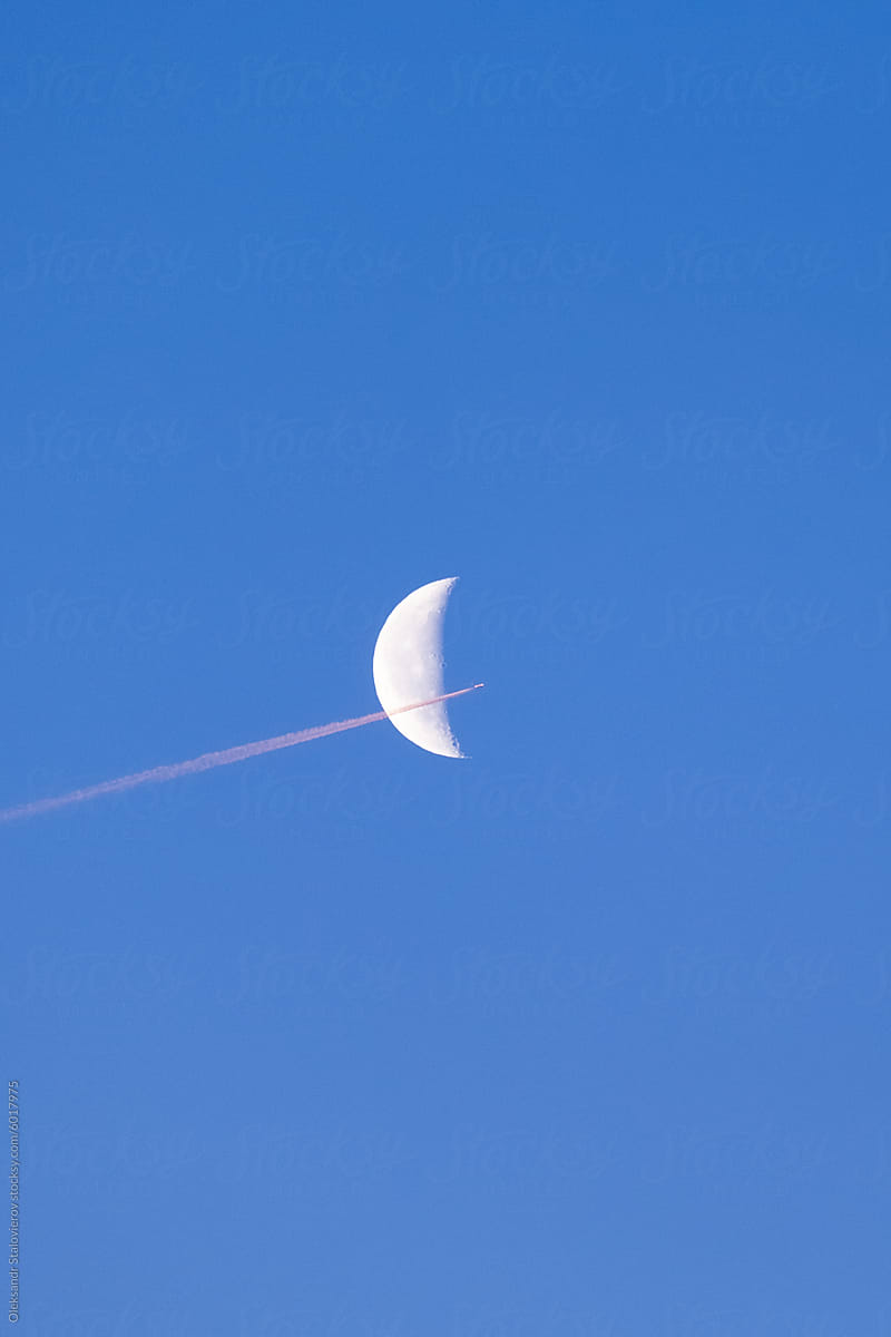Moon and airplane on morning sky.