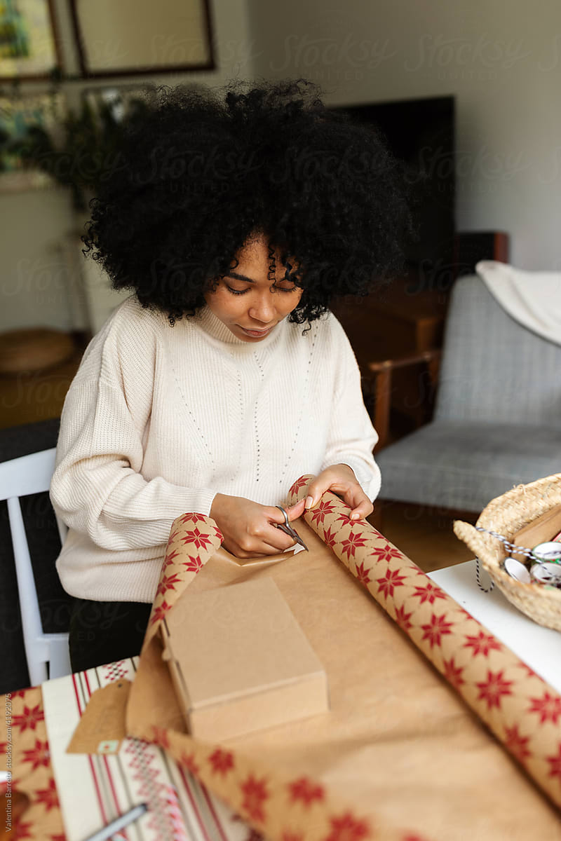 Young woman wrapping Xmas gift