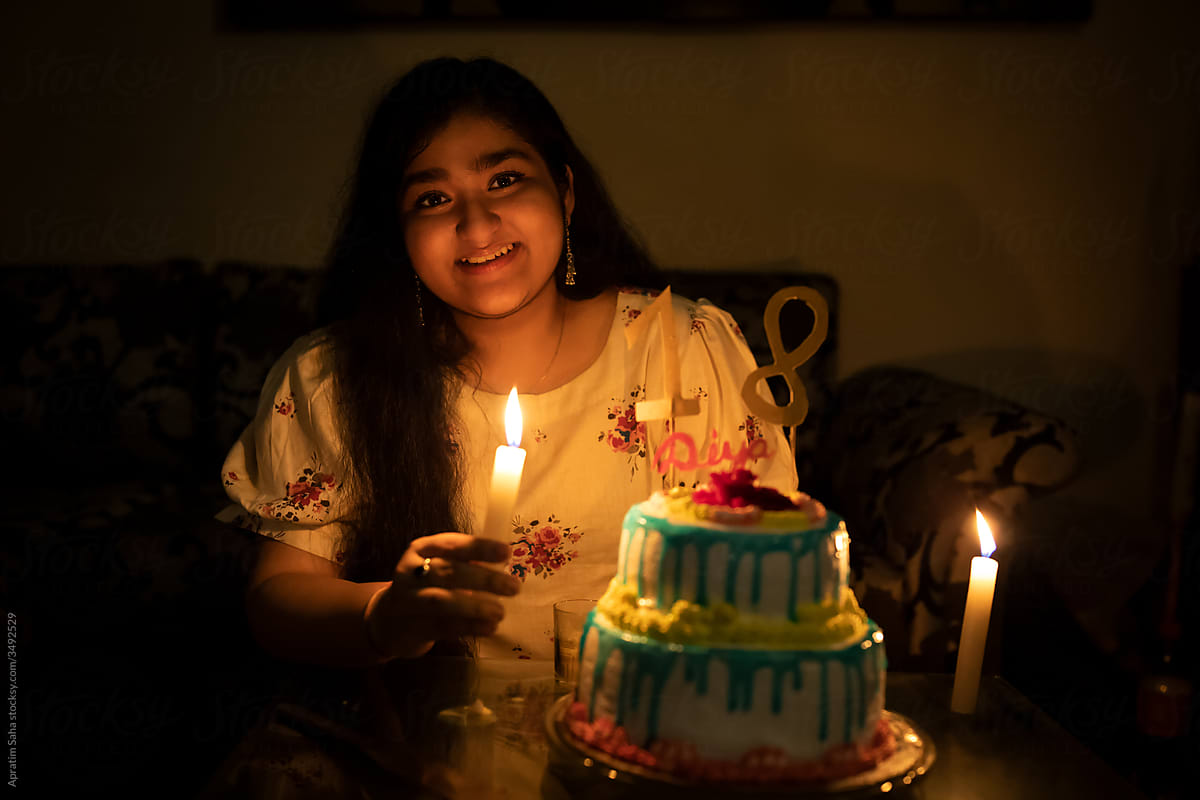 Smiling birthday girl with candles indoor