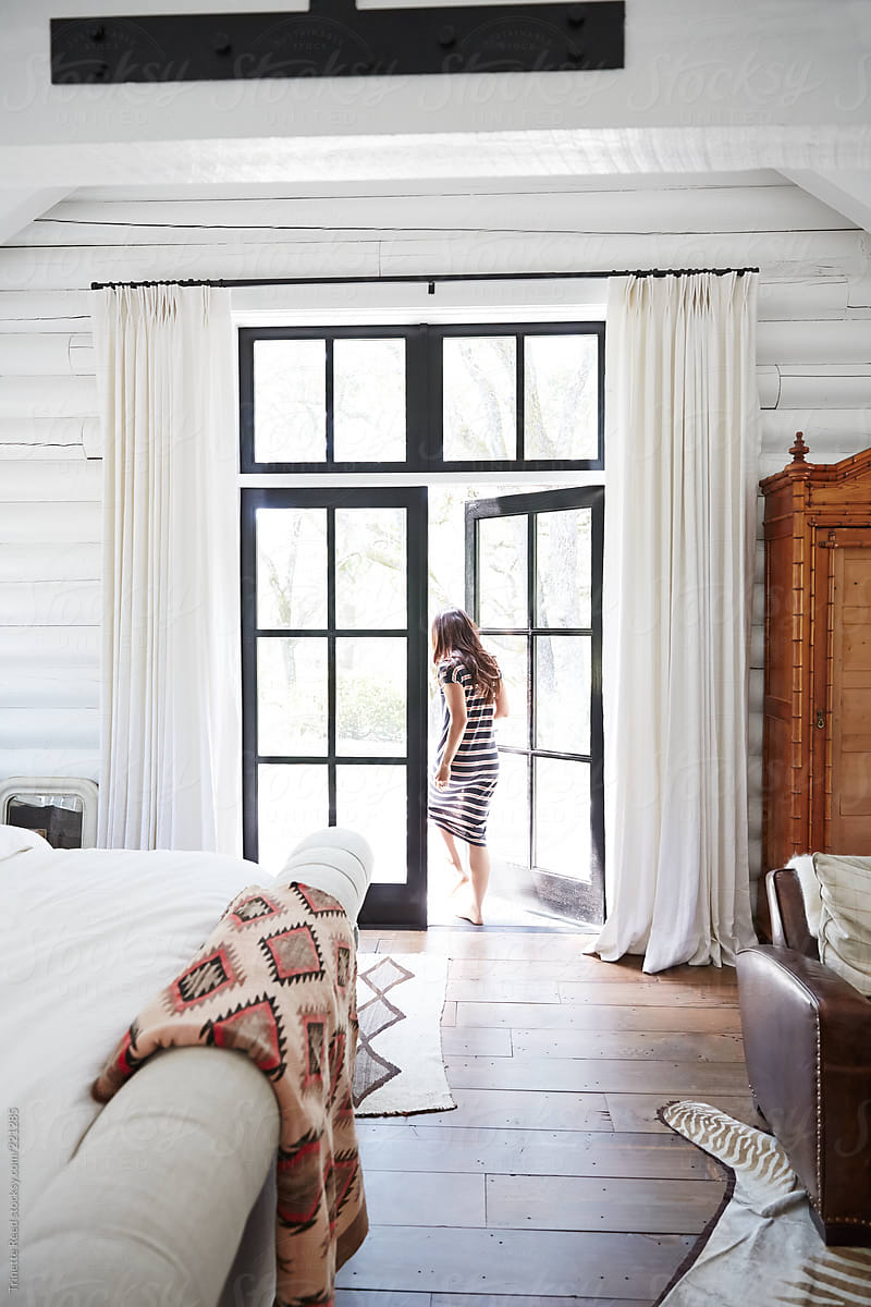 Woman walking out doors in modern design farmhouse bedroom