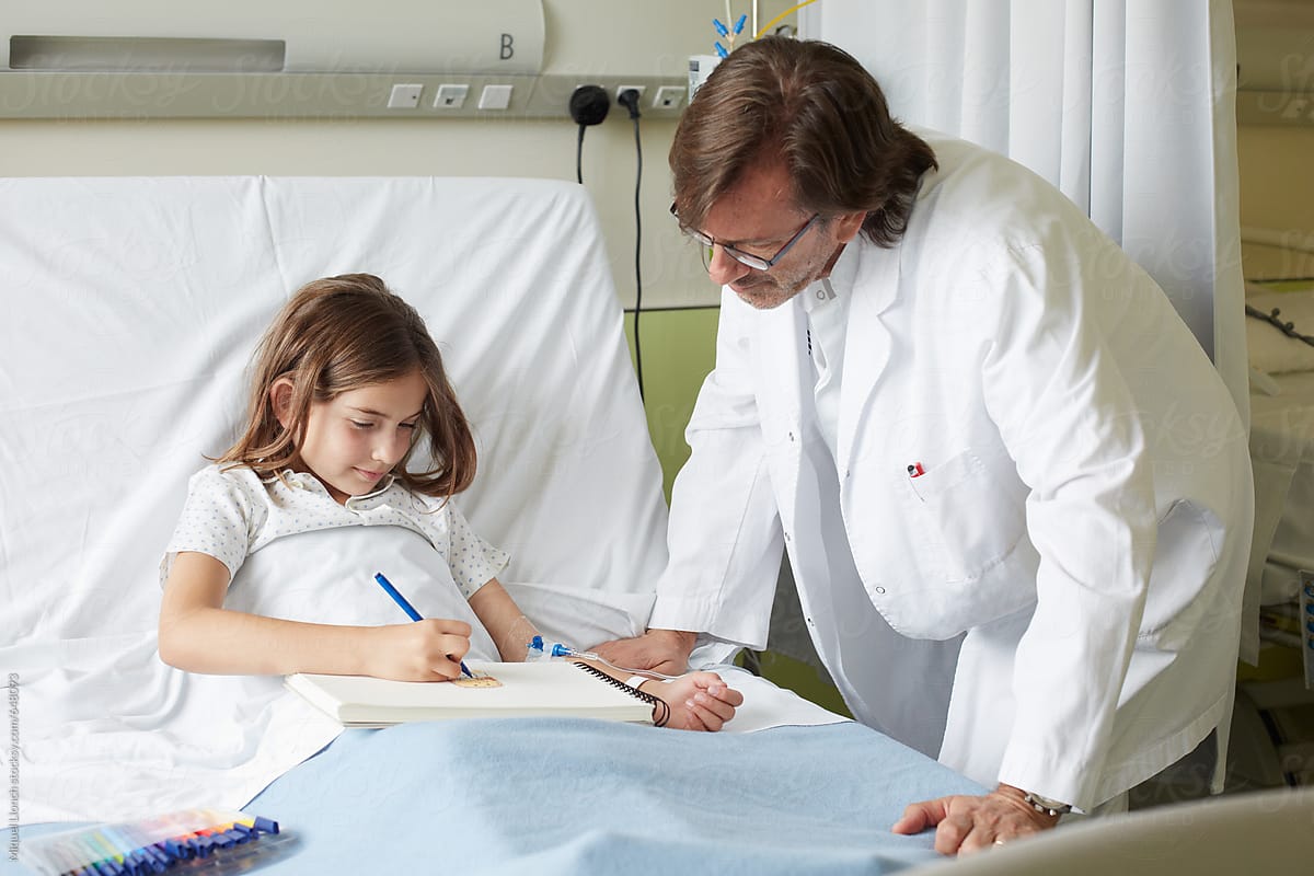 Relaxed moment in a hospital room with little girl patient and doctor