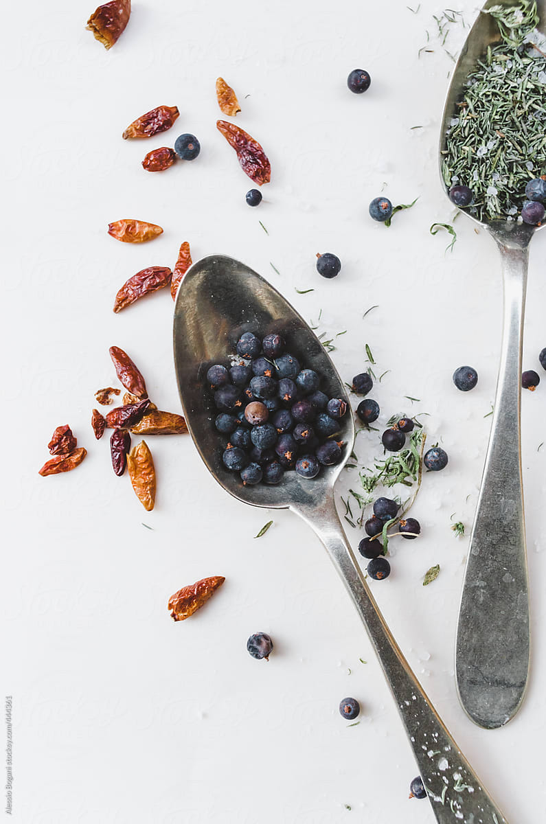 Herbs: Juniper berry, chili peppers and thyme with vintage spoons