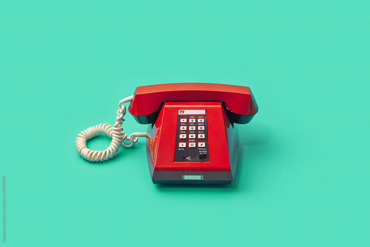 Red vintage telephone over turquoise background