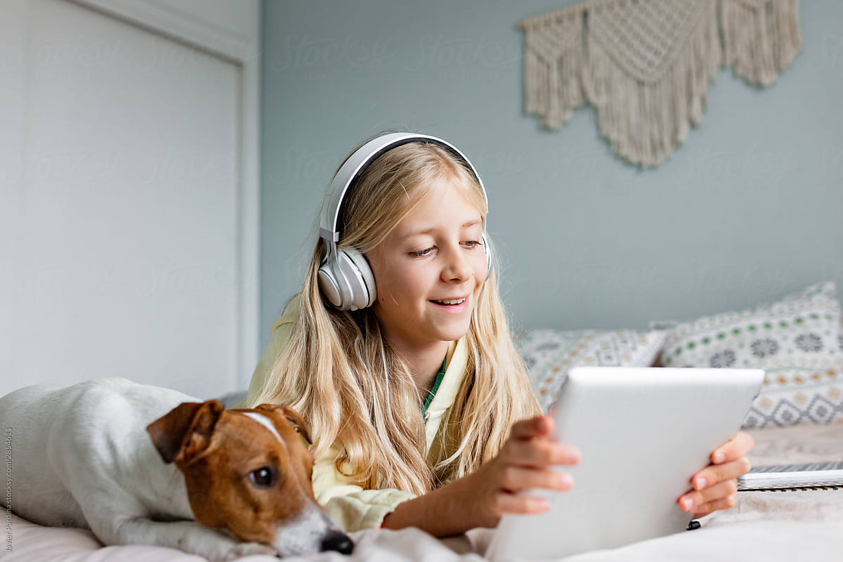 Child using tablet with dog
