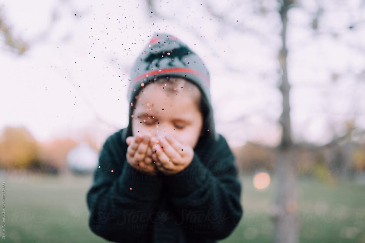 A Young Boy Blowing Christmas Glitter 