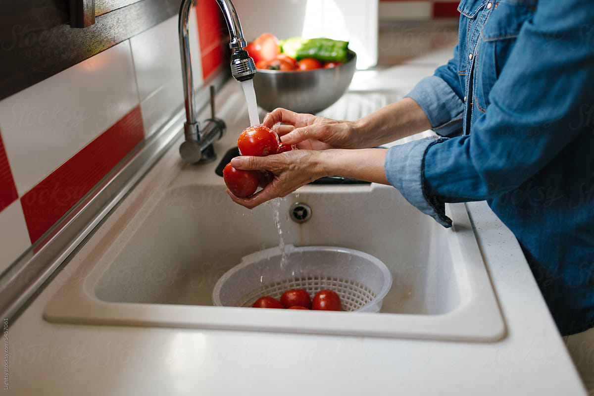 Unrecognizable person washing vegetables