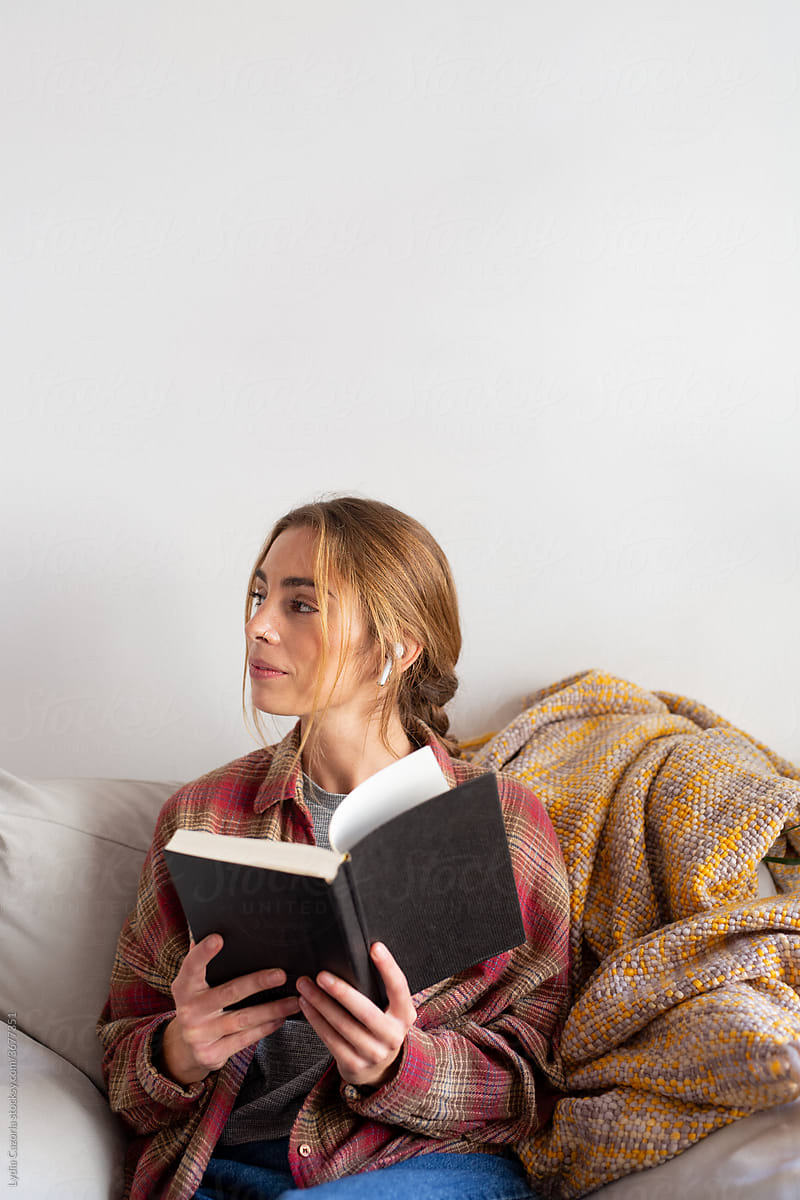 Young woman reading a book in sofa