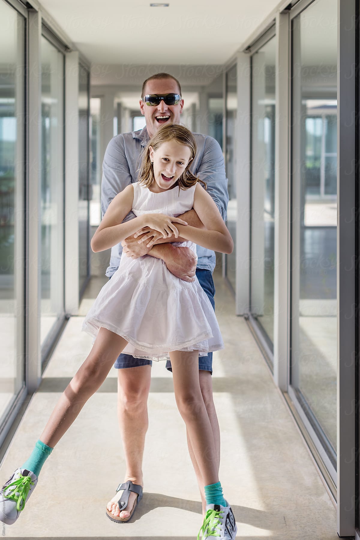 «father And Daughter Laughing In A Hallway Of A Modern Home Del