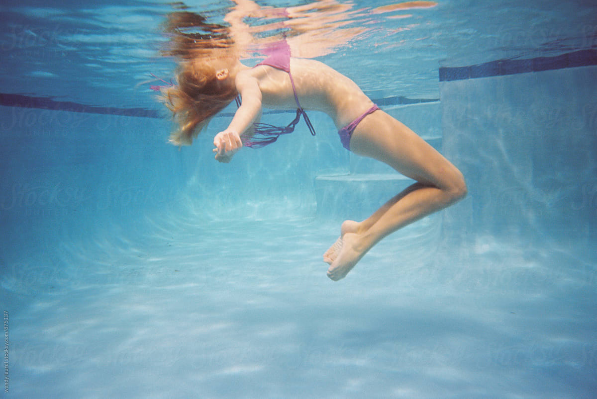girl floating in pool in bikini underwater
