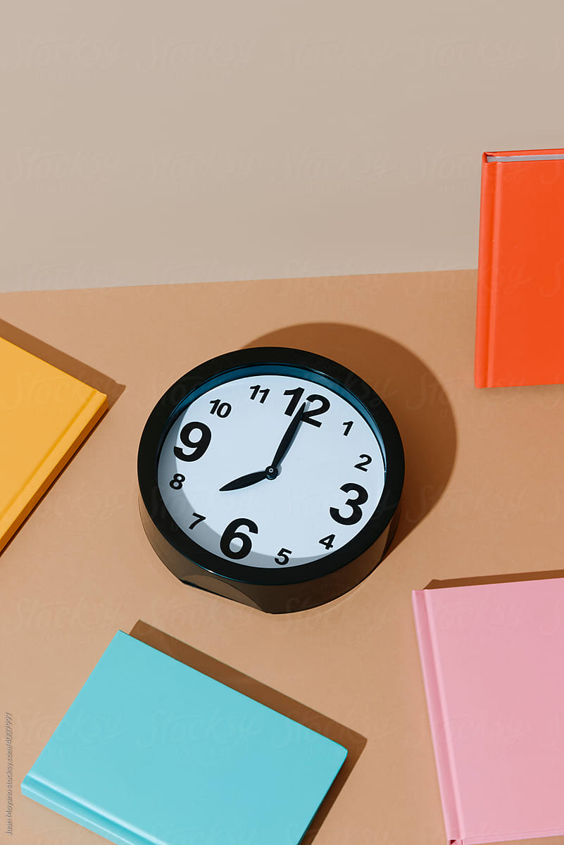 clock at eight and notepads of different colors