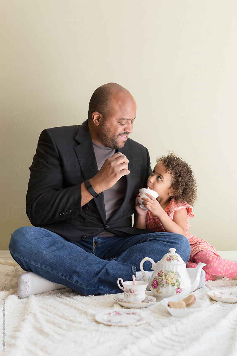 Father smiles at daughter during tea party