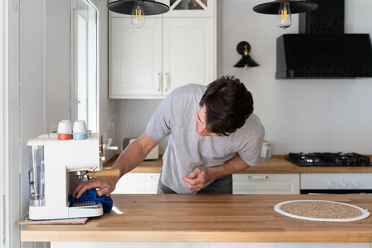 Man cleaning coffeemaker and kitchen