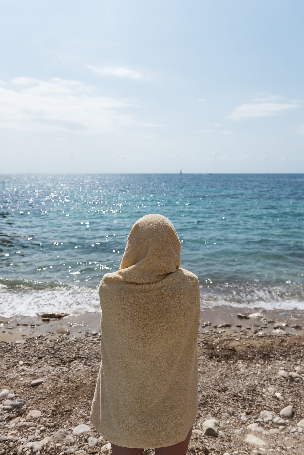 Person in towel admiring seascape