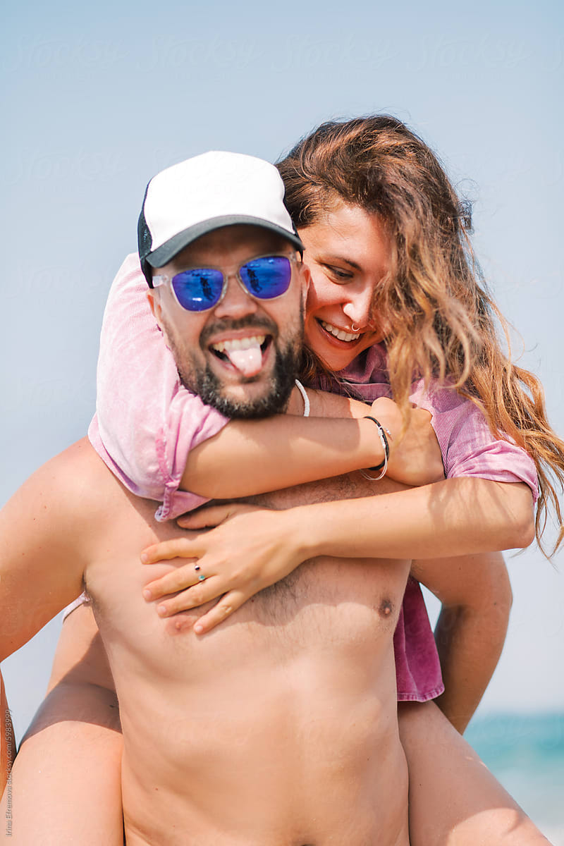 Joyful Couple Embracing at Beach piggy back style