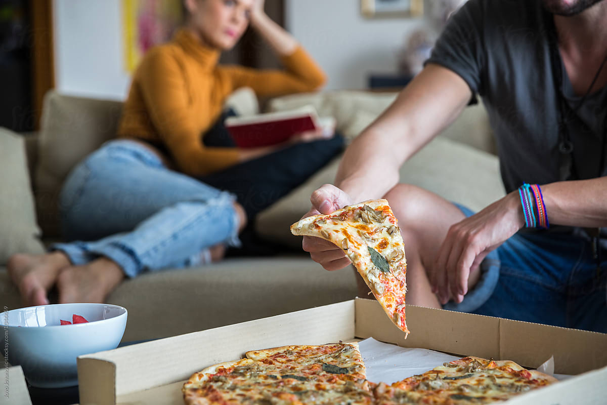 Couple at home having pizza for dinner