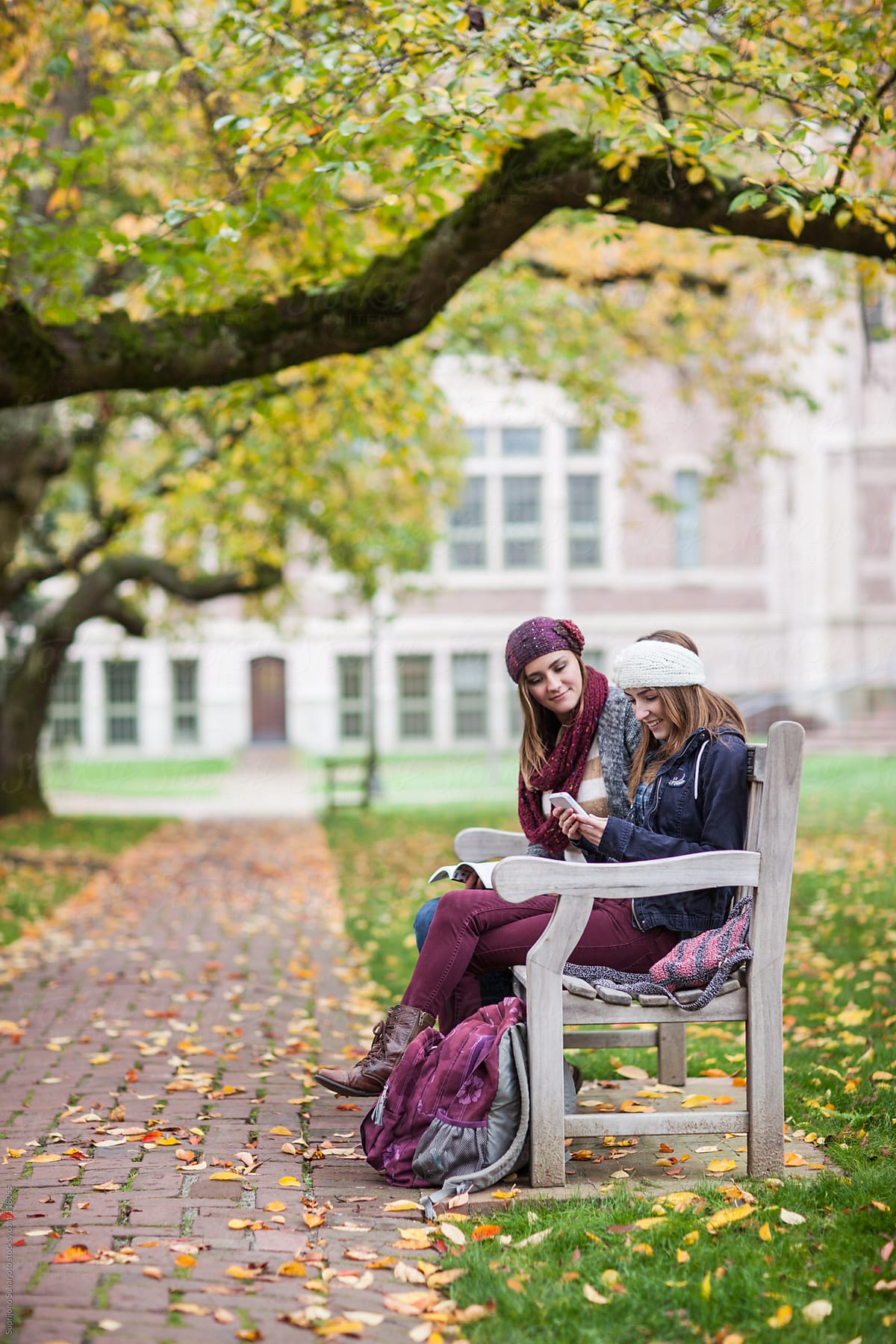 Two female college students looking and laughing at their phones