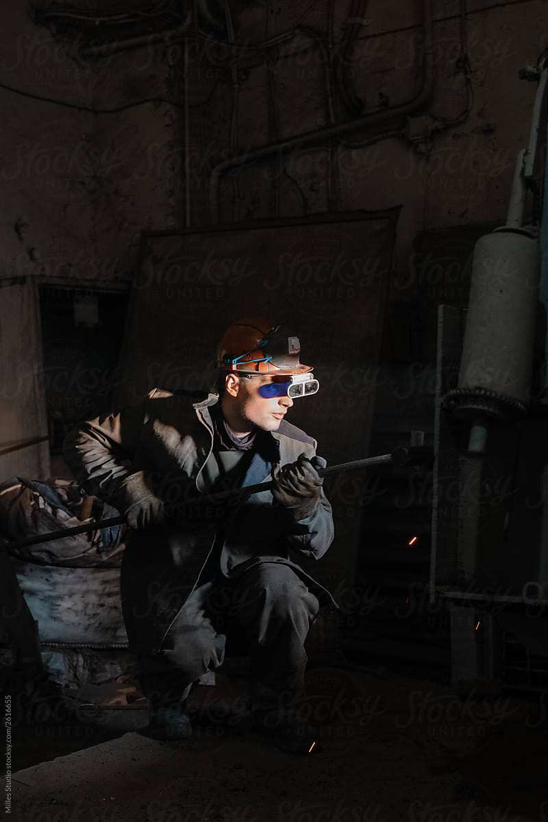 Man in protective glasses working on factory