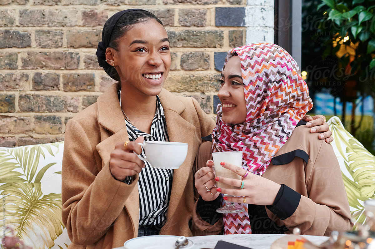 Laughing young Muslim friends having coffee