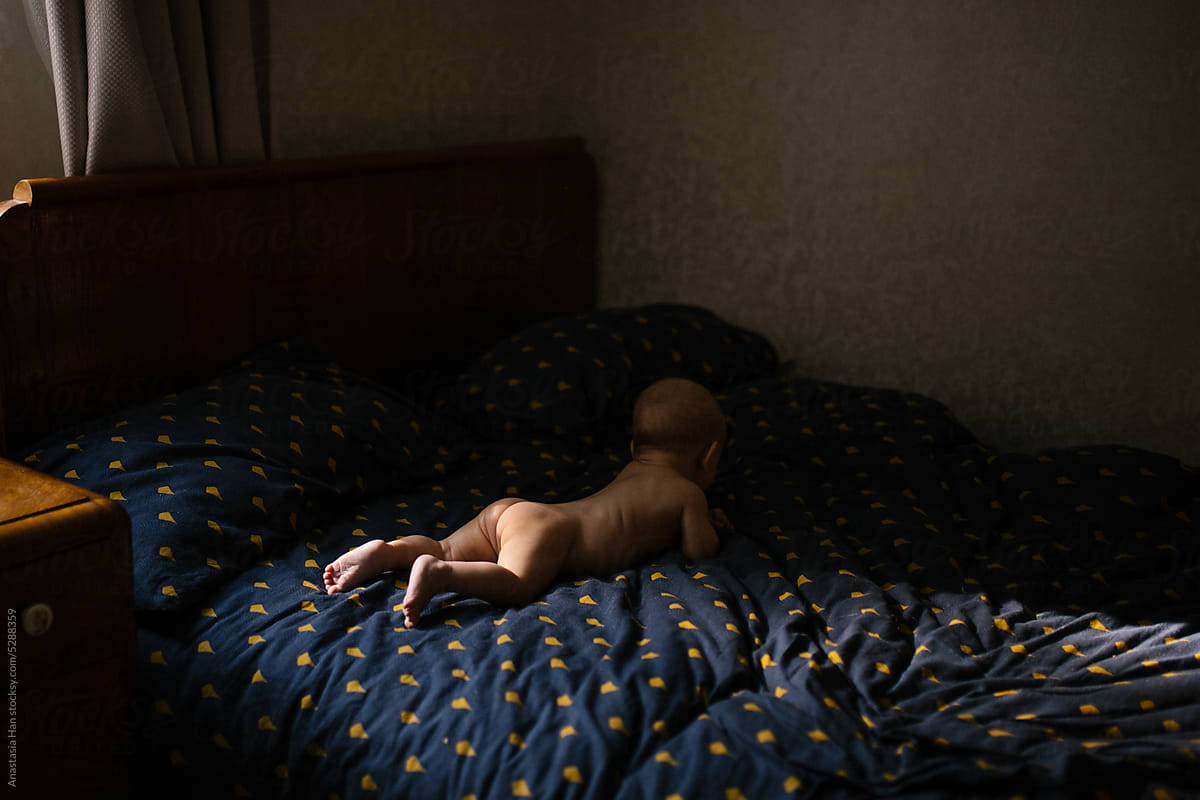 Infant nude lying in the bed