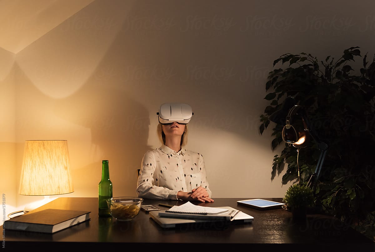 Woman relaxing with VR glasses at table