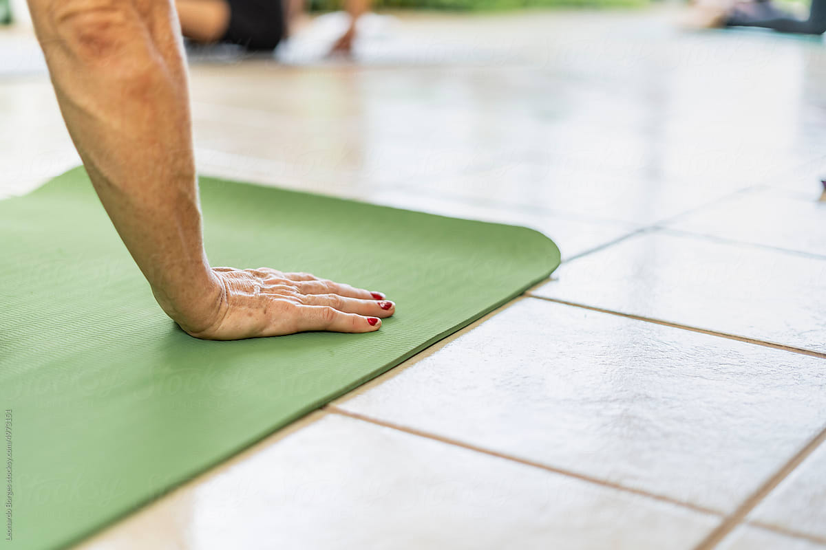 Older adult unrecognizable doing yoga exercises supported by his hand