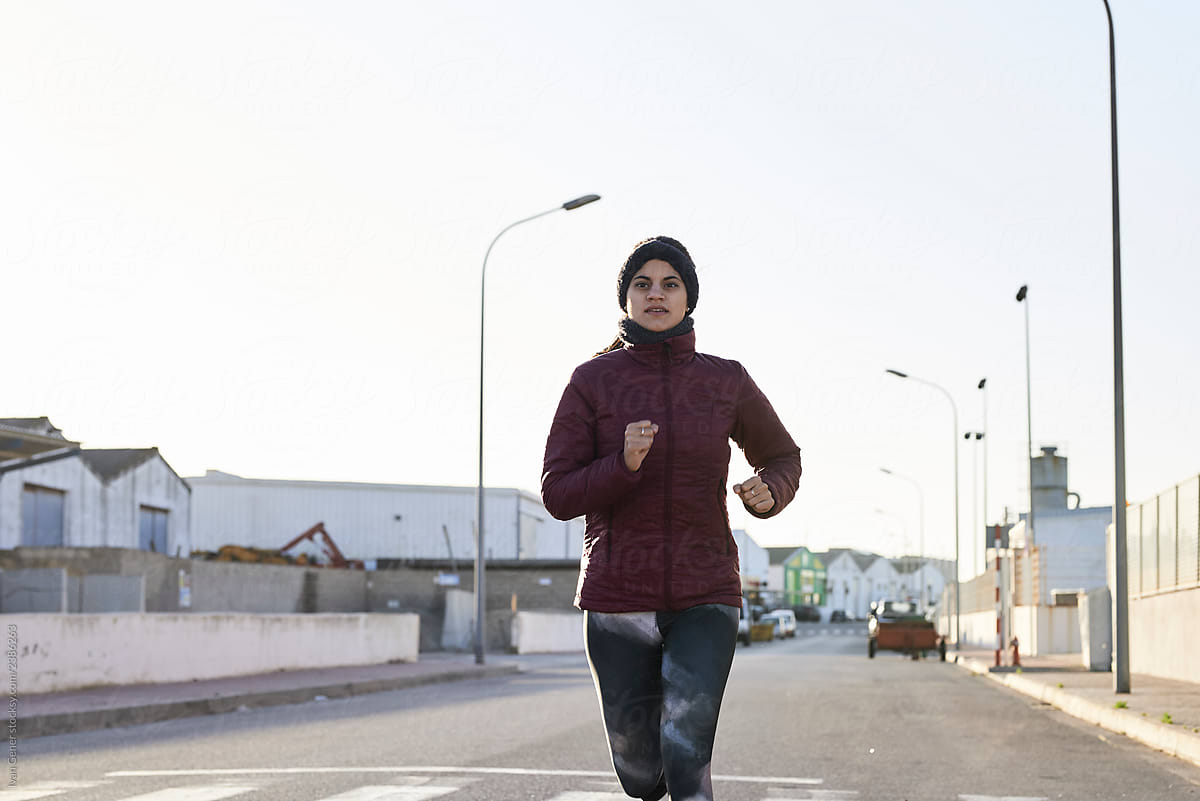 Urban female running in winter.