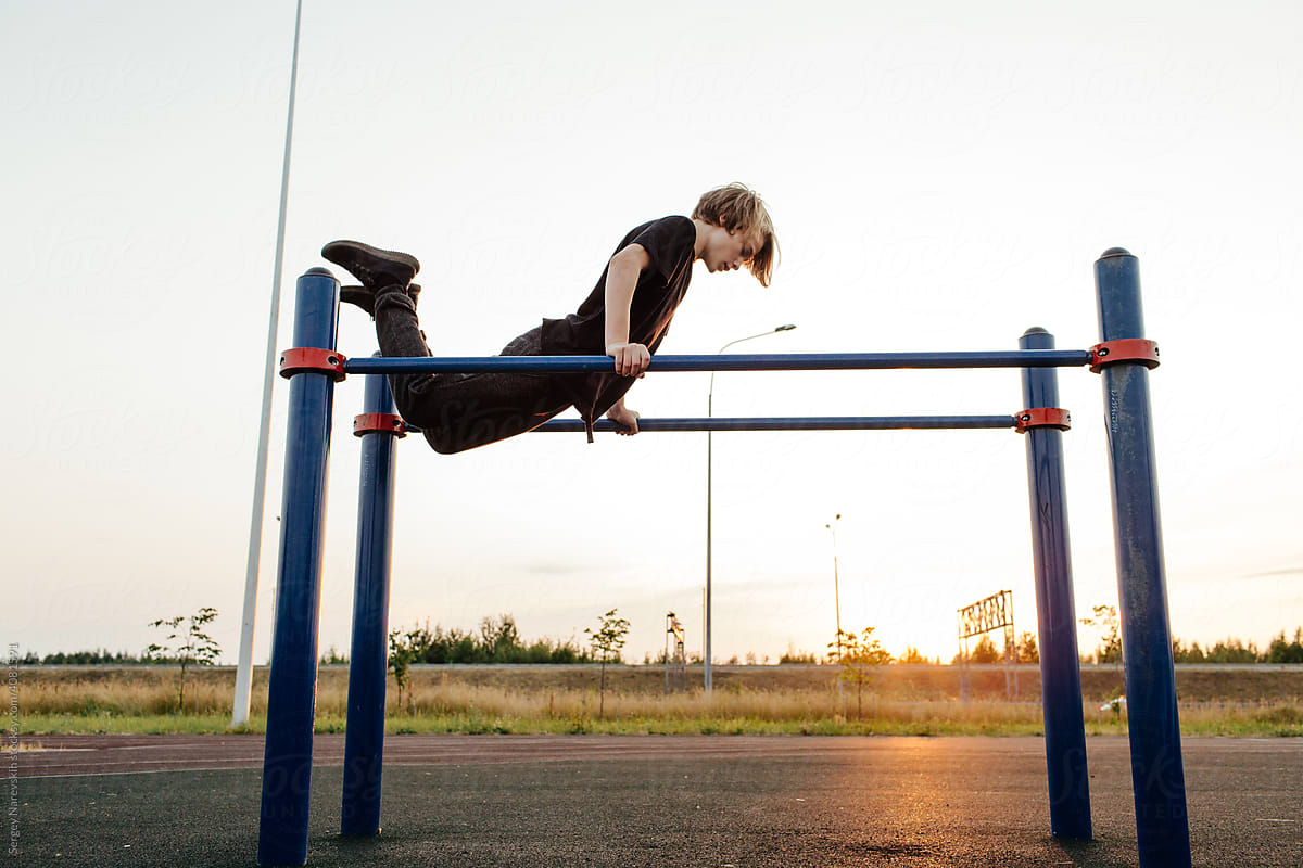 Young guy exercising on parallel bars
