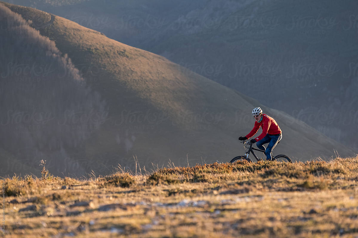 man riding mountain bike in rolling hills
