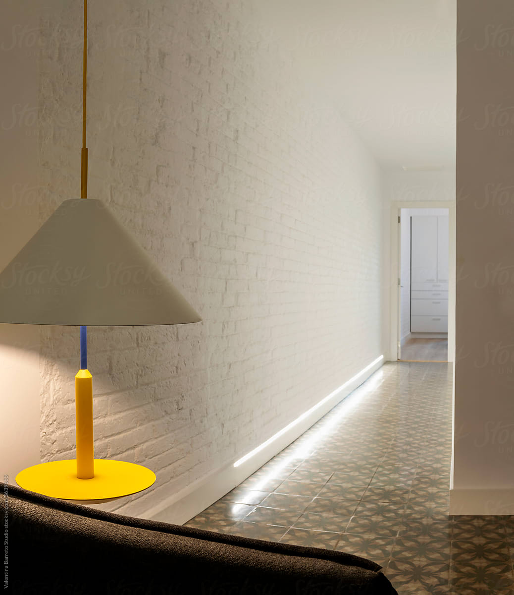 yellow lamp on white brick wall and old tiles floor hall