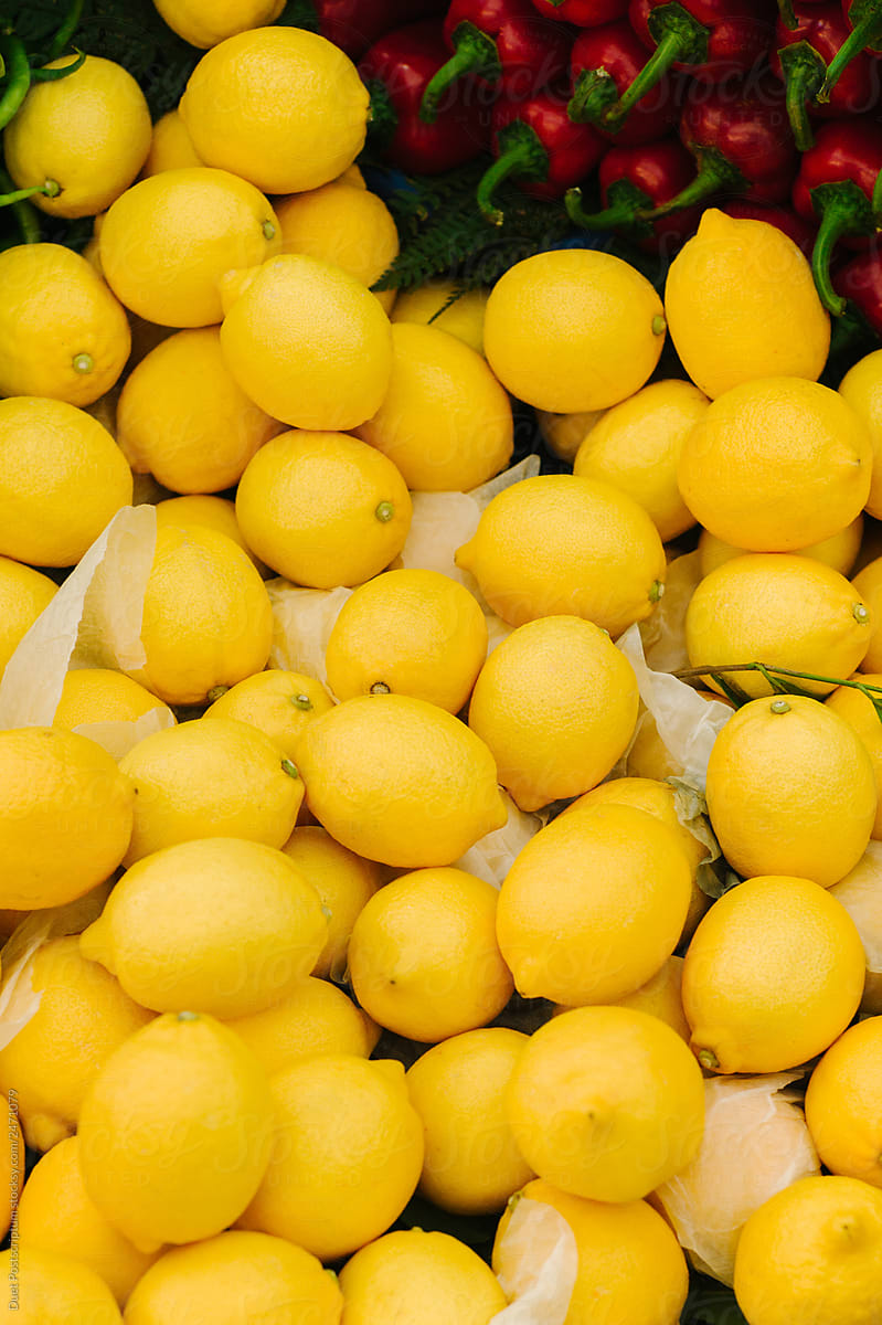 Tasty yellow lemons near peppers selling in shop
