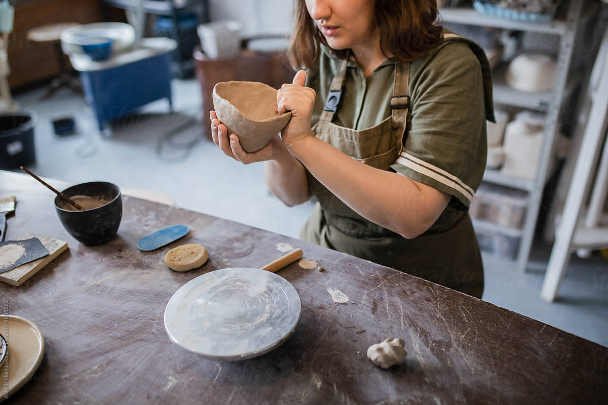 The creative process of creating a clay mug by a female ceramist