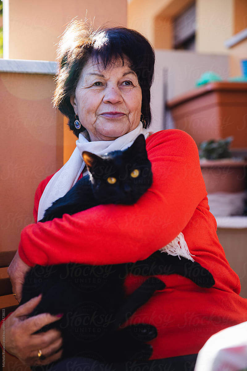 Elderly lady holding her cat in her arms