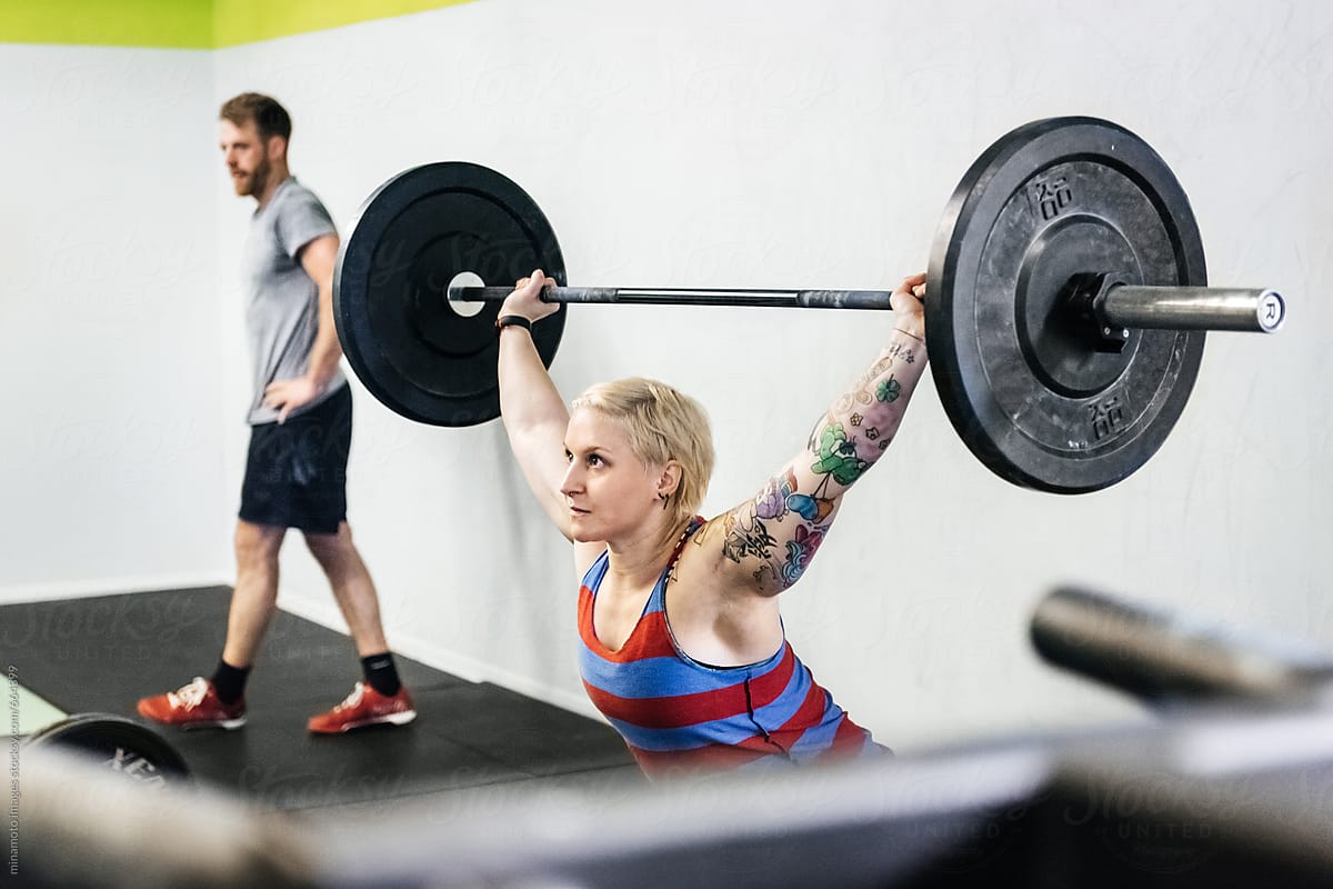 Female Athlete Lifting Weight In Gym
