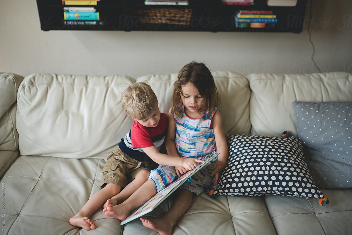 Two Children (siblings) reading at home