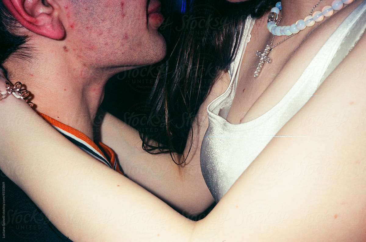 Anonymous couple hugging in a nightclub during a party