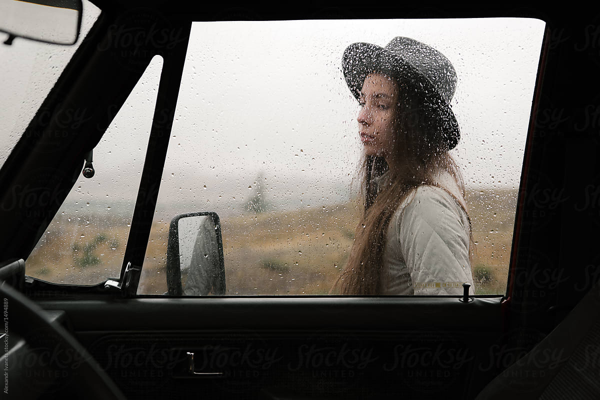 Girl outside of car in rain