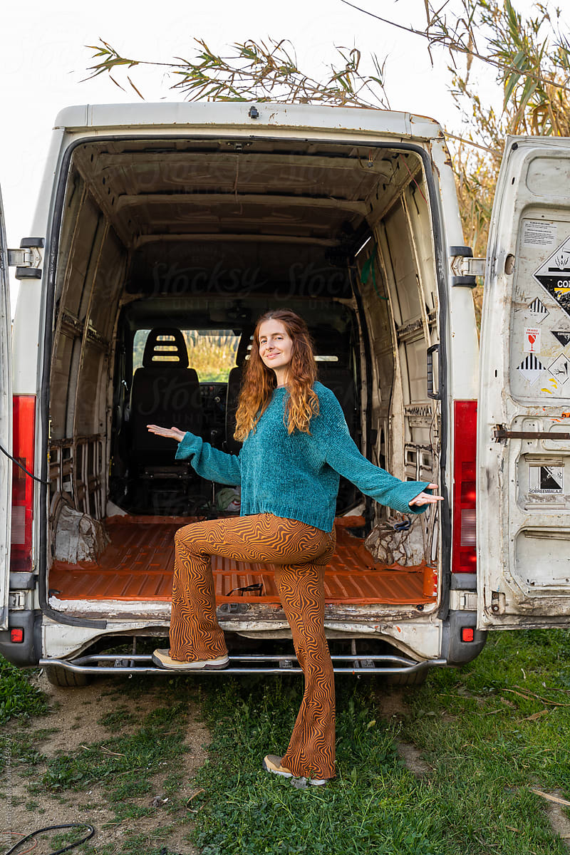 Portrait of woman posing next to old camper van ready to repair it
