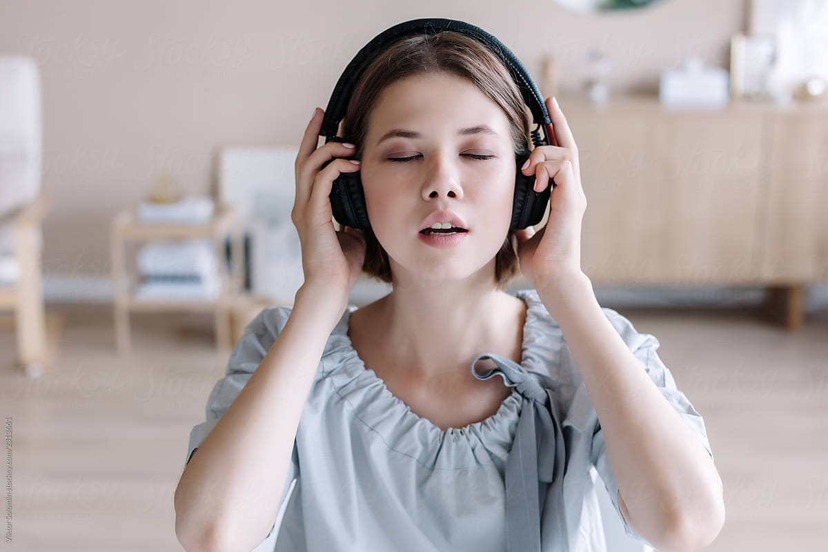 Beautiful closeup portrait of cute asian school girl listening music with headphones