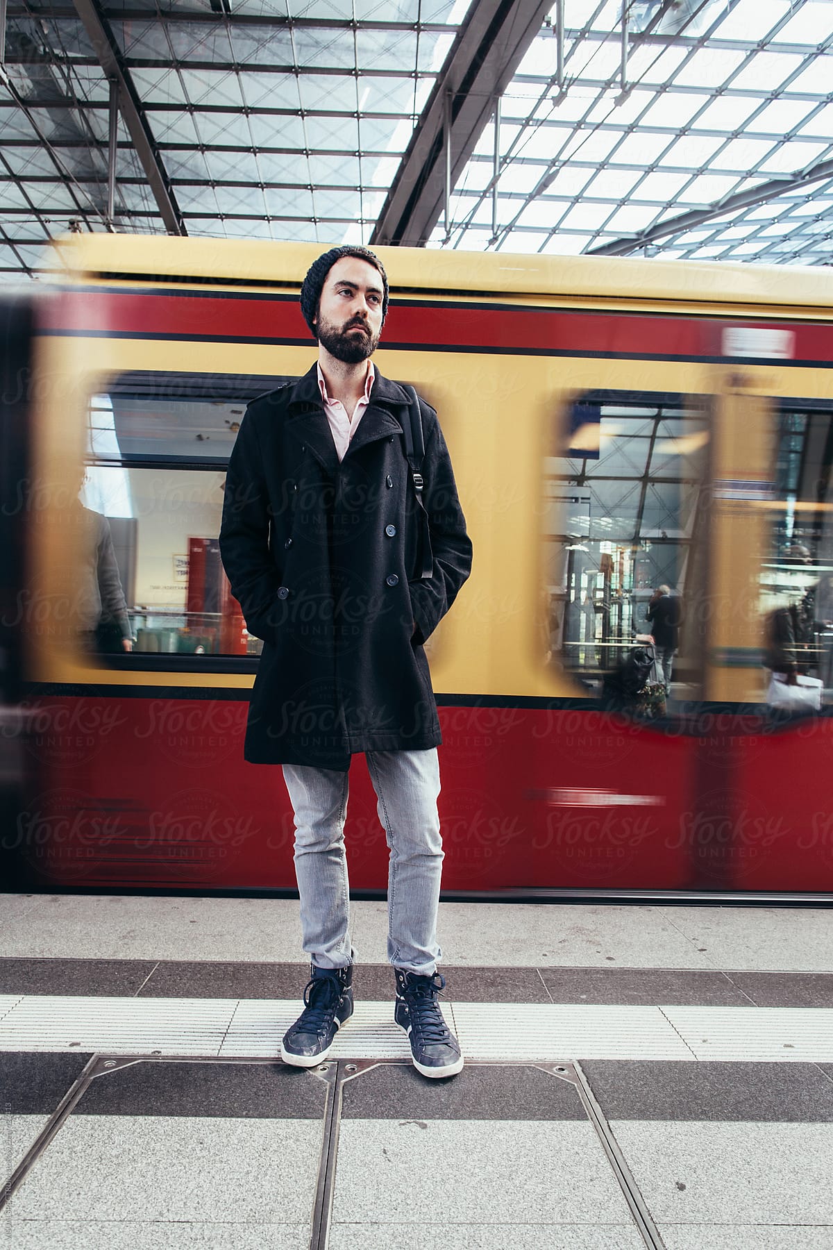 Man With Beard and Beanie Standing in Train Station