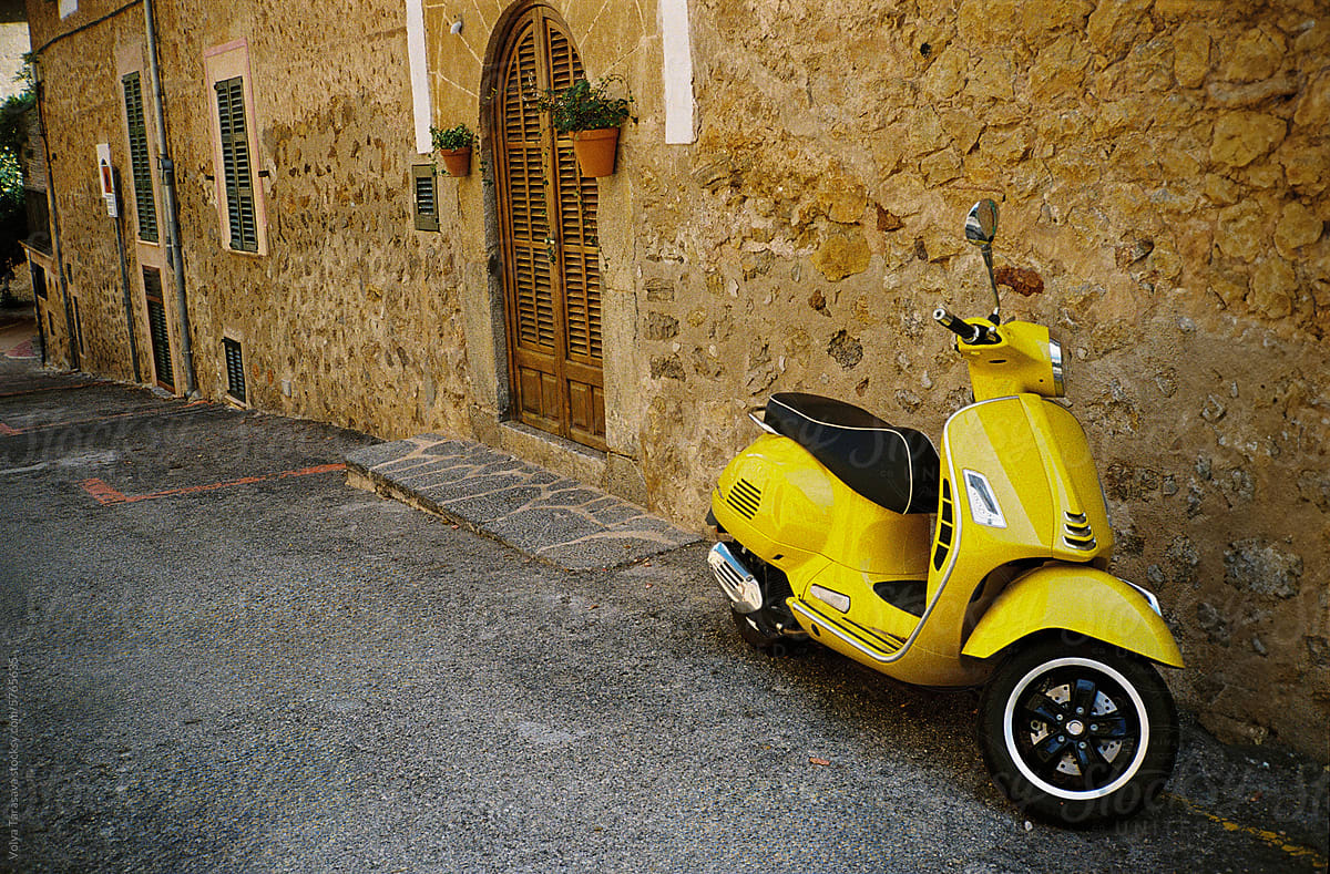 Yellow moped near the traditional stone house