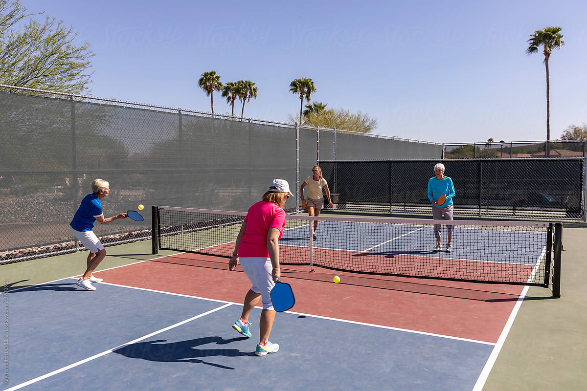 Senior Citizens playing doubles  match on Pickleball court lifestyle