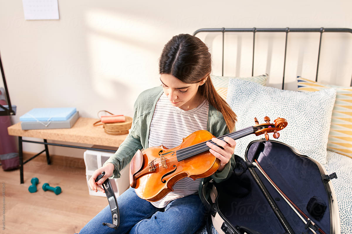 Girl with violin on the bed.