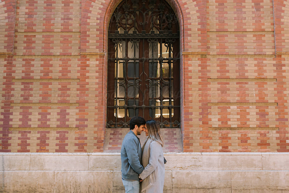 Couple kiss in front of an old building