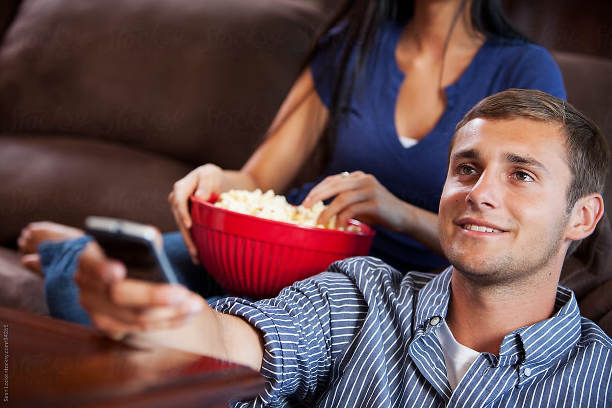 Television: Man Holds Remote Control While Watching TV