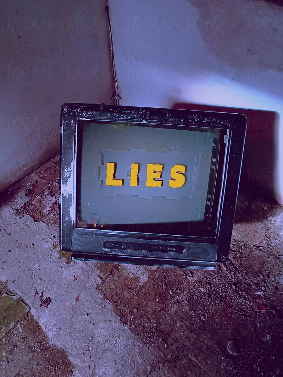 Old TV in a corner displaying LIES message