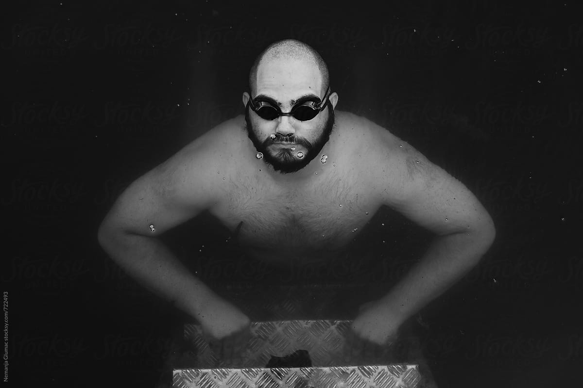 Man With Swimming Goggles Holding Breath Underwater
