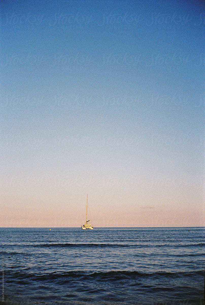 Seascape with a boat on the horizon on sunset