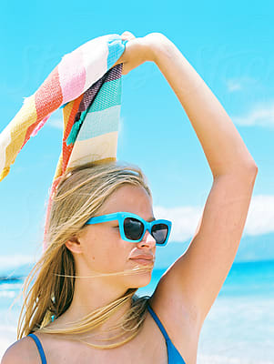 Girl In Bikini Taking Shirt Off At Beach With Ocean by Stocksy Contributor  Wendy Laurel - Stocksy