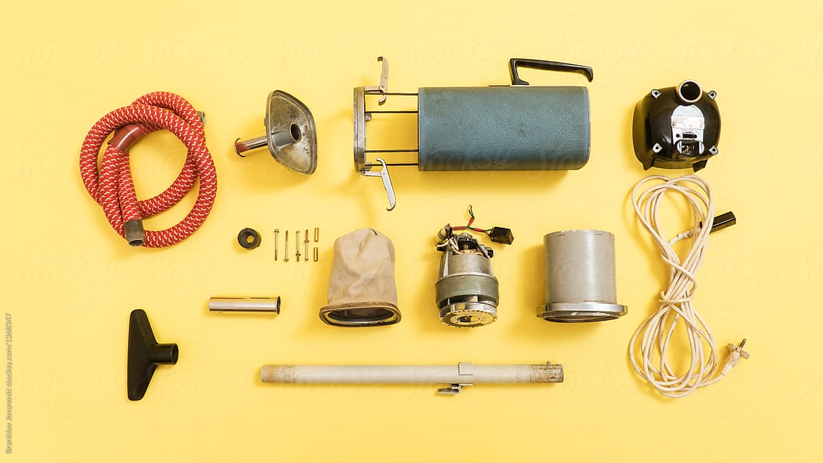 Deconstructed Parts Of An Old Vacuum Cleaner On The Yellow Background